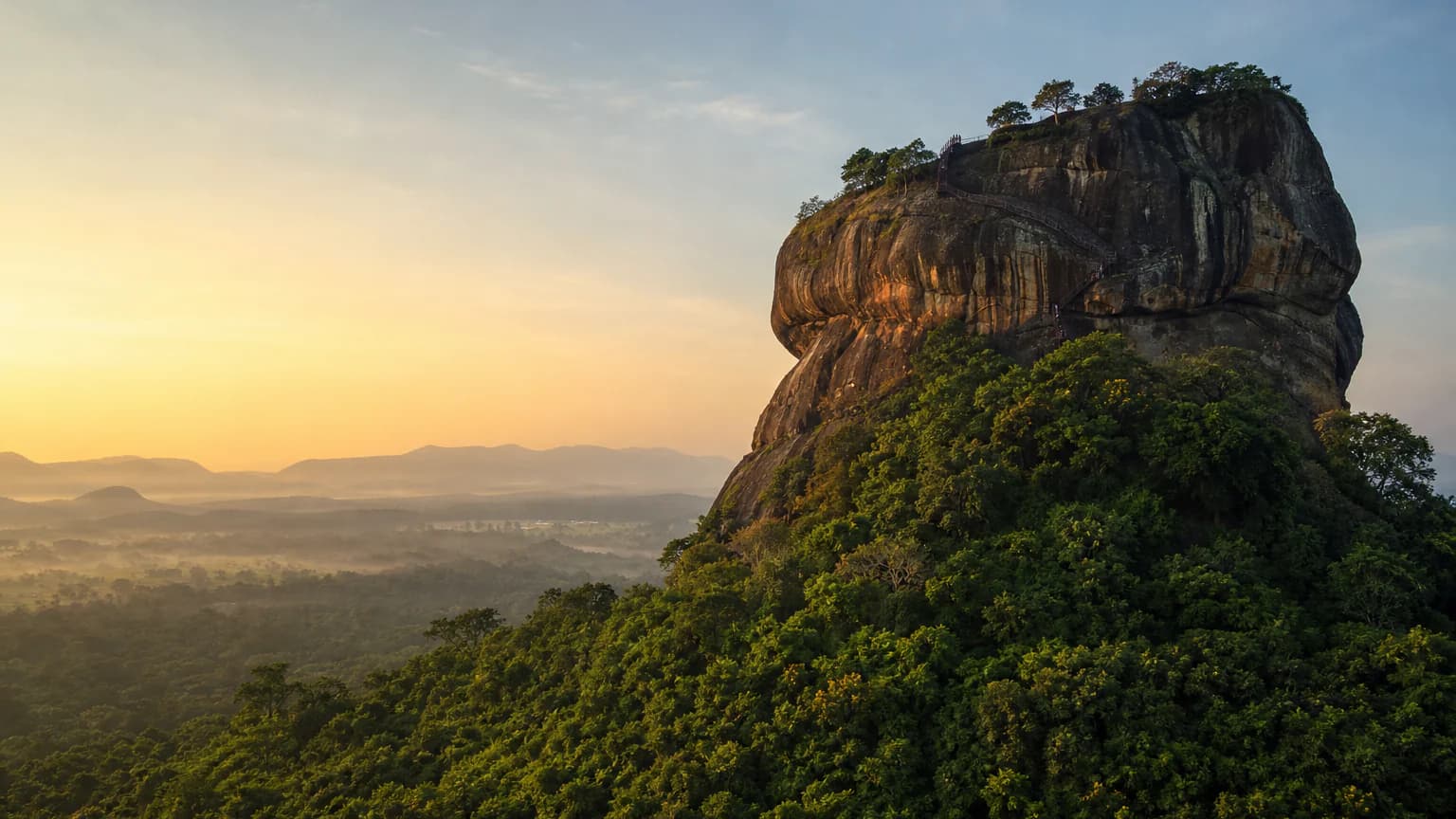 Sigiriya private tour — Sigiriya rock fortress rising above tropical forest at dawn